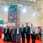 Một Nhóm Lãnh đạo Hội Vật Liệu Xây Dựng vlxd Mặc Comple đứng Chụp ảnh Lưu Niệm Trước Gian Hàng Triển Lãm Của Công Ty Vcc Tại Triển Lãm Vietbuild 2026 Gian Hàng Nổi Bật Với Tháp Trưng Bày Cao vcc Vì Chất Lượng Cuộc Sống Quầy Trưng Bày Keo Silicone Hình Tròn Nhiều Tầng Và Banner vật Liệu Xây Dựng Xanh Cấu Trúc Mái Giàn Không Gian Kim Loại Lớn Phía Trên Bối Cảnh  Vcc Sealant   Sản Xuất Phân Phối Keo Silicone Và Chất Kết Dính Chuyên Nghiệp