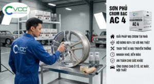 Hình ảnh Sơn Phủ Crom Bạc VCC AC4 trong một ga-ra chuyên nghiệp. Người thợ mặc đồng phục VCC đang sơn phun lớp mạ chrome sáng bóng lên bánh xe hợp kim ô tô. Bên phải là các thông tin về sản phẩm và logo VCC đầy đủ màu ở góc trên bên trái.