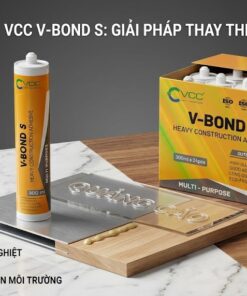 Một bức ảnh của keo VCC V-Bond S heavy construction adhesive, hiển thị tuýp 300ml đứng trên bề mặt đá cẩm thạch và gỗ, bên cạnh một phần thùng carton 24 tuýp. Các mẫu ứng dụng bao gồm một tấm Alu nhỏ với chữ Mica nổi 