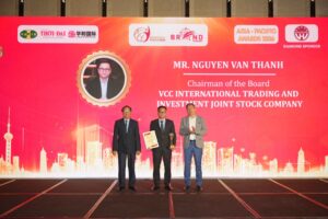 Chủ tịch Nguyễn Văn Thành cầm cúp vàng và bằng chứng nhận của Thương hiệu VCC trên sân khấu lớn tại hội nghị APEC 2026