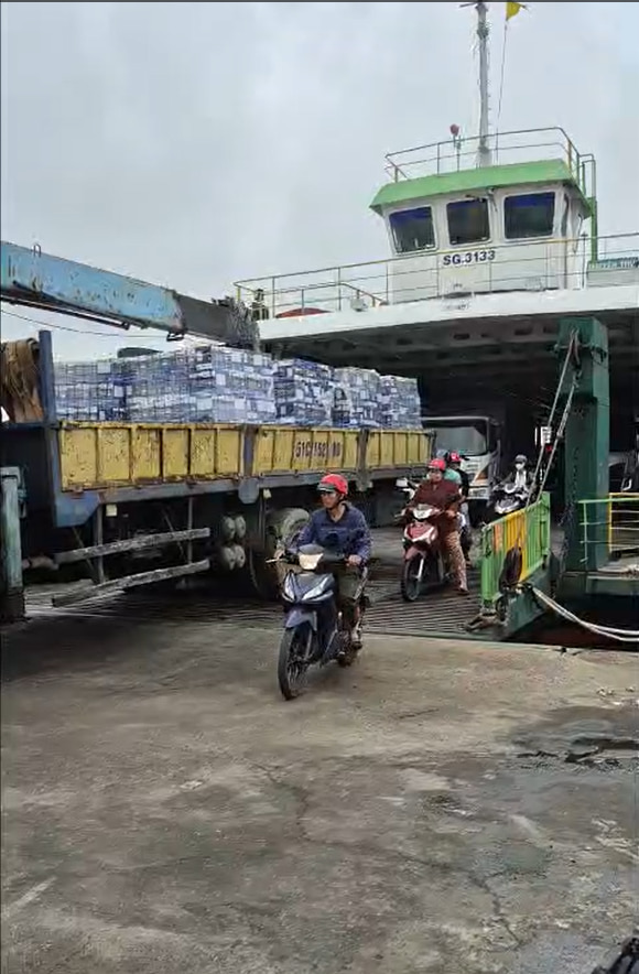 Xe tải lớn vận chuyển các kiện hàng keo VCC qua phà để cung ứng cho dự án ven biển Cần Giờ.